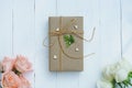 Brown eco friendly gift box decorated with soft pink and white rose on white wooden table, sweet lovely present valentine concept Royalty Free Stock Photo
