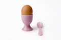 Brown egg in egg cup with spoon on white Royalty Free Stock Photo