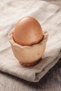 Brown egg in handmade holder on rustic table
