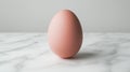 Brown egg on a marble surface with a soft focus background Royalty Free Stock Photo