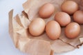 Brown egg in paper bag behind on a light colored background,Fresh chicken eggs on wood table