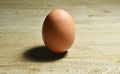 brown egg shell with shadow on wooden table background Royalty Free Stock Photo