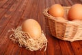 Brown egg in straw nest and in the basket Royalty Free Stock Photo