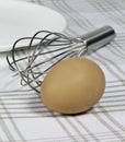 Brown egg, whisk, and plate Royalty Free Stock Photo