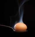 Brown egg wrapped in smoke in spoon