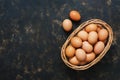 Brown eggs in a basket on an old dark surface. Top view, space for text. Royalty Free Stock Photo