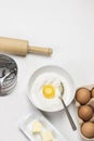 Brown eggs in carton container. Butter and whisk on plate. Egg yolk with flour in bowl Royalty Free Stock Photo