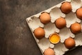 Brown eggs in a carton, one egg is broken. View from above Royalty Free Stock Photo