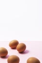 Brown eggs on pink and white background Royalty Free Stock Photo