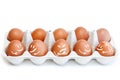 10 brown eggs in the shape for eggs with funny happy and angry painted faces isolated on white Royalty Free Stock Photo