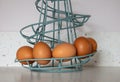 Brown eggs in a turquoise wire spiral basket Royalty Free Stock Photo