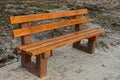 Brown empty bench on the sidewalk in the park Royalty Free Stock Photo