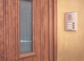 Brown entrance door with intercom on stucco wall Royalty Free Stock Photo