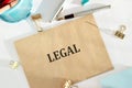 A brown envelope with the word LEGAL printed on it sits on a white desk Royalty Free Stock Photo