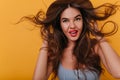 Brown-eyed girl posing with long hair waving and laughing. Close-up indoor photo of wonderful caucasian lady with bronze Royalty Free Stock Photo