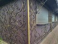 On the brown facade of a small kiosk, golden wrought-iron scrolls create an ornate background pattern Royalty Free Stock Photo