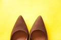 Brown female shoes on a yellow background Royalty Free Stock Photo