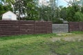 Brown fence wall and gray gate made of boards