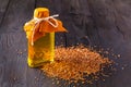 Brown flax seeds in spoon and flaxseed oil in glass bottle on white wooden background. Flax oil is rich in omega-3 fatty acid Royalty Free Stock Photo