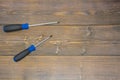 On the brown floor to the left are two screwdrivers with blue handles. Locksmith tools on wooden brown boards Royalty Free Stock Photo