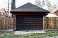 Brown garage and part of the wooden fence in the street on the road Royalty Free Stock Photo