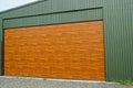 brown gate on the green metal wall of a street garage Royalty Free Stock Photo