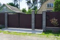 brown gate and part of a fence made of metal and bricks Royalty Free Stock Photo