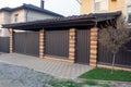 Brown gate and part fence made of metal and bricks Royalty Free Stock Photo