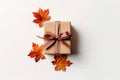 Brown gift box with brown glitter ribbon bow and maple leaves isolated on white background, top view, Thanksgiving or birthday Royalty Free Stock Photo