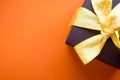 Brown gift box with yellow ribbon on orange background. Top view with copy space. Royalty Free Stock Photo