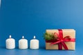 Brown gift boxes with red ribbons and candles on blue trendy background. Festive backdrop for projects. Color of the year. Present Royalty Free Stock Photo