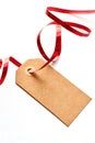 Brown gift tag with curly red ribbon Royalty Free Stock Photo