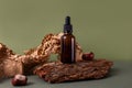 Brown glass bottle of cosmetic product or oil on wood and paper on green background. Natura Spa Cosmetic Beauty concept