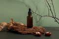 Brown glass bottle of cosmetic product or oil on wood and paper on green background. Natura Spa Cosmetic Beauty concept