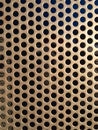 Brown/gold metal grate texture with holes close