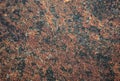 Brown granite, the surface of a natural stone of a rich dark color with small black blotches Royalty Free Stock Photo