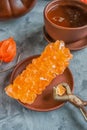 Brown Grape sugar in clear crystals, tea and tongs on grey slate close-up. Oriental sweetness to tea Royalty Free Stock Photo