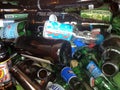 Brown green glass bottles in metal recycle bin