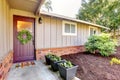 Brown grey house exterior with front door and spring landscape. Royalty Free Stock Photo