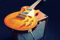 Brown guitar combo amplifier with honey sunburst guitar on black background. Gently toned Royalty Free Stock Photo