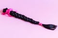 Brown hair braid on pink background for hair donation for women with cancer chemotherapy
