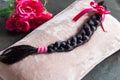 Brown hair braid on pink background for hair donation for women with cancer chemotherapy Royalty Free Stock Photo