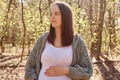 Brown haired pregnant woman enjoying peaceful moments in park embracing nature's serenity and finding comfort during Royalty Free Stock Photo