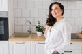 Brown haired woman in great mood posing in kitchen smiling copy space - housewife and good positive mood and diet Royalty Free Stock Photo