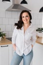 Brown haired woman in great mood posing in kitchen smiling - housewife and good positive mood and diet vertical format Royalty Free Stock Photo