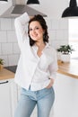 Brown haired woman in great mood posing in kitchen smiling - housewife and good positive mood and diet vertical format Royalty Free Stock Photo