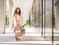 Brown-haired woman smiling holding colourful shopping bags Royalty Free Stock Photo