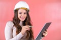 Brown-haired woman in hardhat with smile prepares project Royalty Free Stock Photo