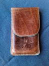 Brown handmade leather case for a smartphone on a blue background Royalty Free Stock Photo