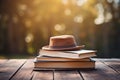 Brown hat on stack of books on wooden table, colorful background with copy space for text or design Royalty Free Stock Photo